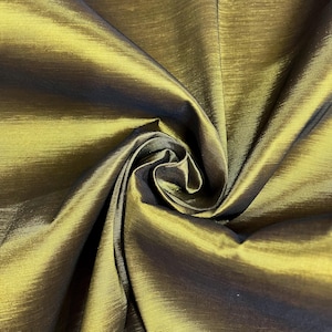 May include: A close-up of a gold fabric with a subtle sheen. The fabric is wrinkled and folded, showing its texture.