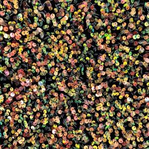 Può includere: Primo piano di un tessuto ricoperto di paillettes iridescenti in tonalità di verde, arancione e oro.