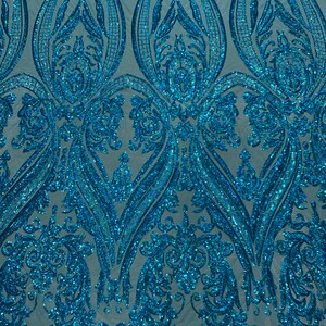 Puede incluir: Paillettes azul turquesa iridiscentes en un patr&oacute;n de damasco sobre una tela de malla transparente. Las lentejuelas est&aacute;n dispuestas en un patr&oacute;n repetitivo de remolinos y hojas.