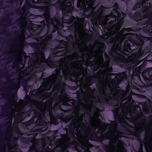 May include: Purple 3D floral fabric with a textured rose pattern. The fabric is made of a soft, lightweight material and is perfect for adding a touch of elegance to any project.