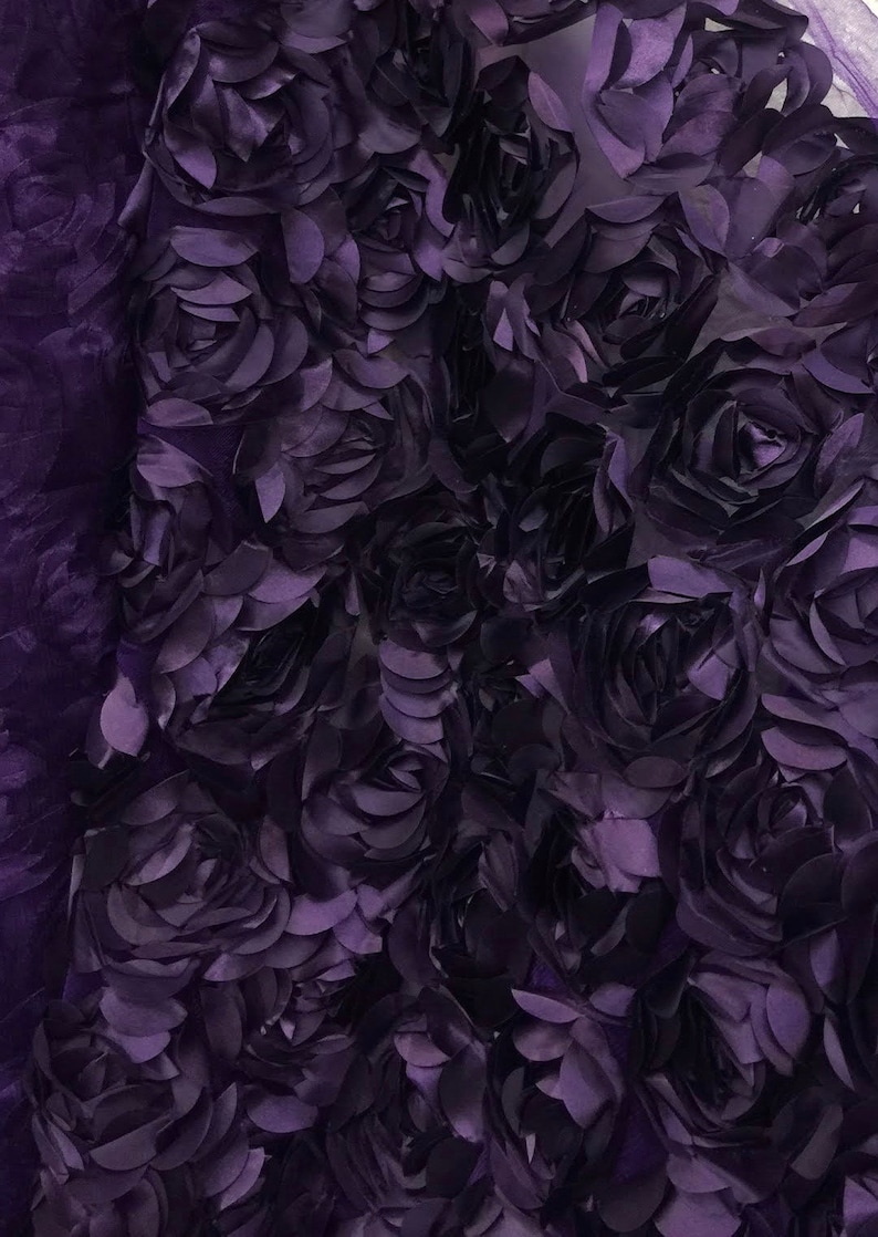 May include: Purple 3D floral fabric with a textured rose pattern. The fabric is made of a soft, lightweight material and is perfect for adding a touch of elegance to any project.
