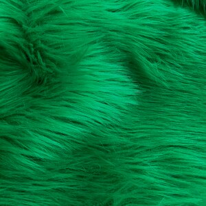 May include: A close-up of a soft, plush fabric with a deep green color. The fabric has a fuzzy texture, resembling fur.
