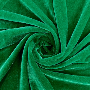 May include: A close-up of a deep green velvet fabric, with a swirling, spiral pattern. The fabric is soft and luxurious, with a subtle sheen.
