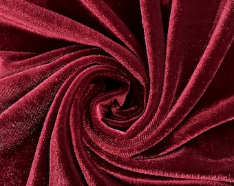 May include: Close-up of a deep red velvet fabric with a swirling pattern. The fabric is soft and luxurious, with a subtle sheen.