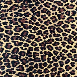 May include: A close-up of a brown and black leopard print fabric. The fabric has a soft, velvety texture.