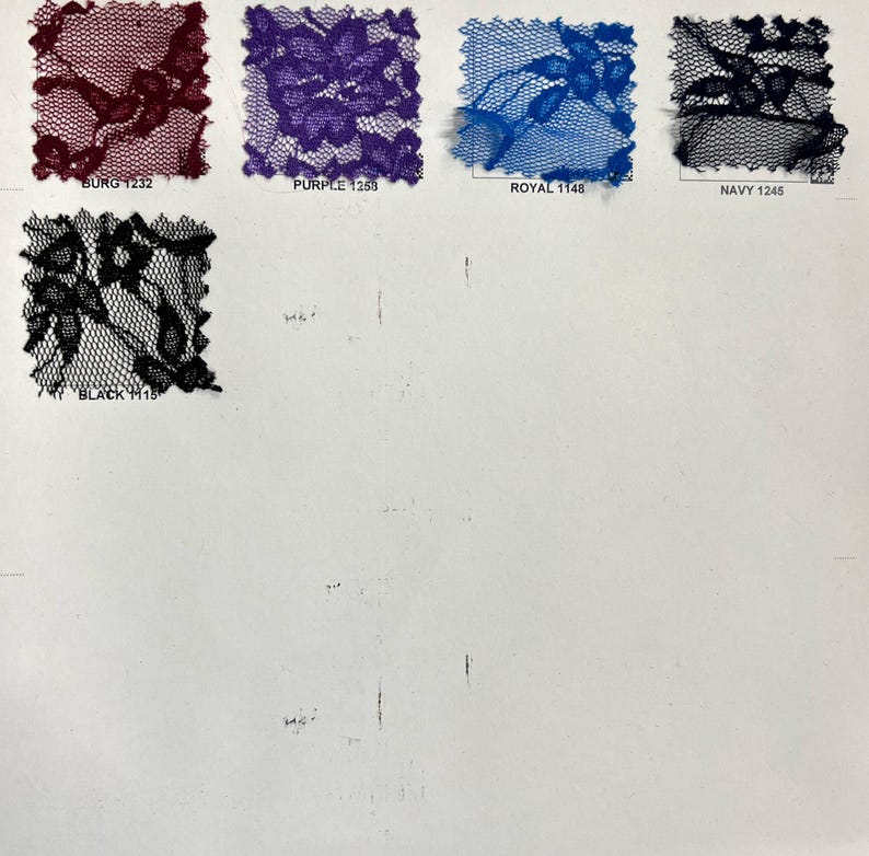 May include: A selection of lace fabric samples in shades of burgundy, purple, royal blue, navy, and black. Each square swatch displays a detailed floral design. The colour names are printed beneath each sample.