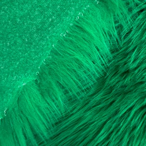 May include: A close-up of a bright green faux fur fabric. The fabric has a soft, plush texture and a subtle sheen.