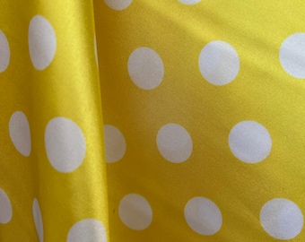 May include: Yellow fabric with white polka dots. The fabric is folded in half, showing the pattern on both sides.