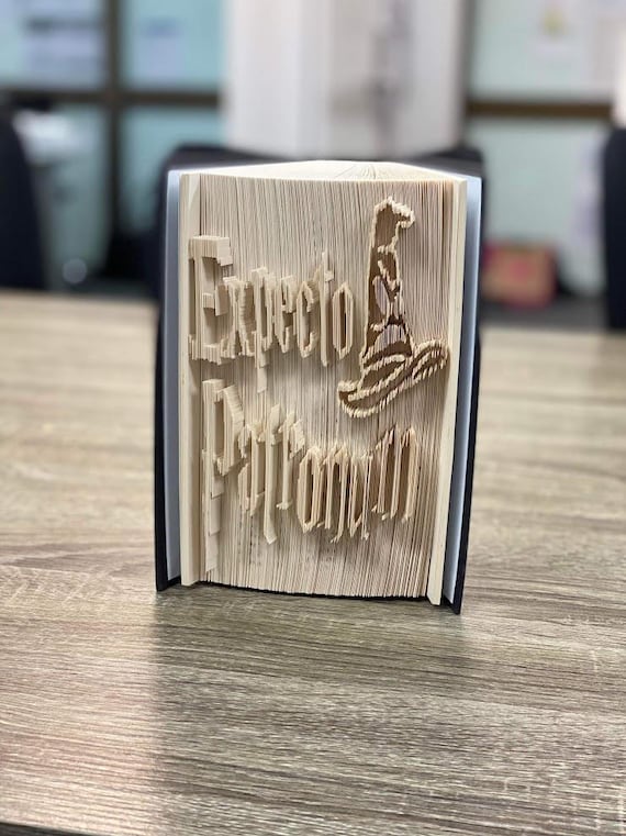 Hundreds of book pages hand-folded into the shape of a Patronus charm — recycled art that took real skill and screams 'a human made this specifically for you'.