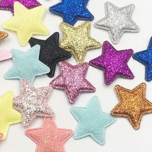 May include: Assortment of sparkly, felt star shapes in various colours, including pink, blue, gold, silver, and purple. The stars are approximately 5 cm in size.