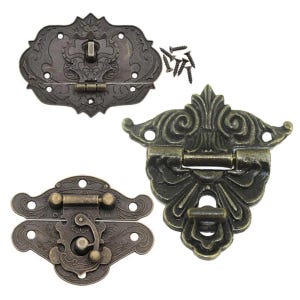 May include: Three antique-style metal clasps with ornate designs. The clasps are in a bronze finish and have intricate details. The clasps are used for securing boxes, chests, or other items.
