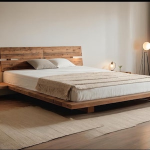 Peut inclure: Un lit en bois moderne avec une tête de lit et des tables de chevet intégrées. Le lit est en bois clair et comprend un matelas blanc, une couverture beige et deux oreillers. La pièce a une palette de couleurs neutres avec un tapis et un lampadaire.