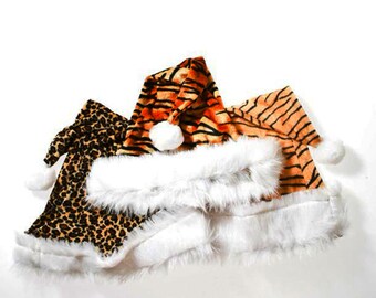 May include: Three Christmas hats with a white fur trim. One hat is orange and black with a tiger stripe pattern, one is brown and black with a leopard print, and one is a solid orange color.