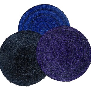 Puede incluir: Tres alfombras redondas y mullidas en diferentes tonos de azul. Las alfombras están hechas de un material suave y peludo y tienen un patrón circular.