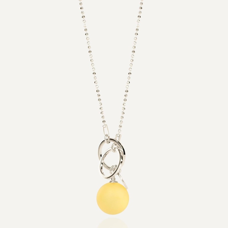 Close up of large lemon yellow amber pendant with 925 sterling silver bead chain