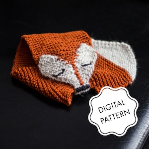 May include: A knitted fox scarf in orange and gray with the text "DIGITAL PATTERN" on a white cloud-shaped tag.