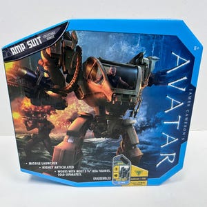 May include: A blue box featuring an Avatar AMP SUIT collectible vehicle. The box shows a detailed image of the AMP SUIT, a missile launcher, and the text "Highly Articulated". The box also includes the text "Works with most 3 3/4" RDA figures, sold separately."