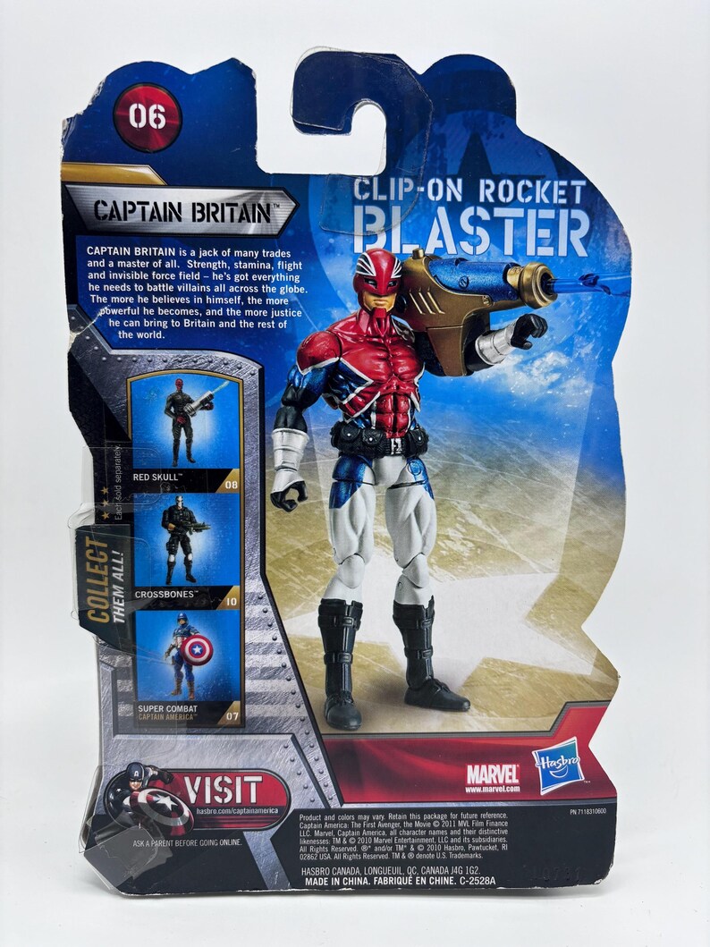 Pu&ograve; includere: Action figure di Captain Britain con un blaster a clip, confezionata su una scheda blu e bianca. La figura &egrave; rossa, bianca e blu, con stivali neri. La confezione include i loghi Marvel e Hasbro.