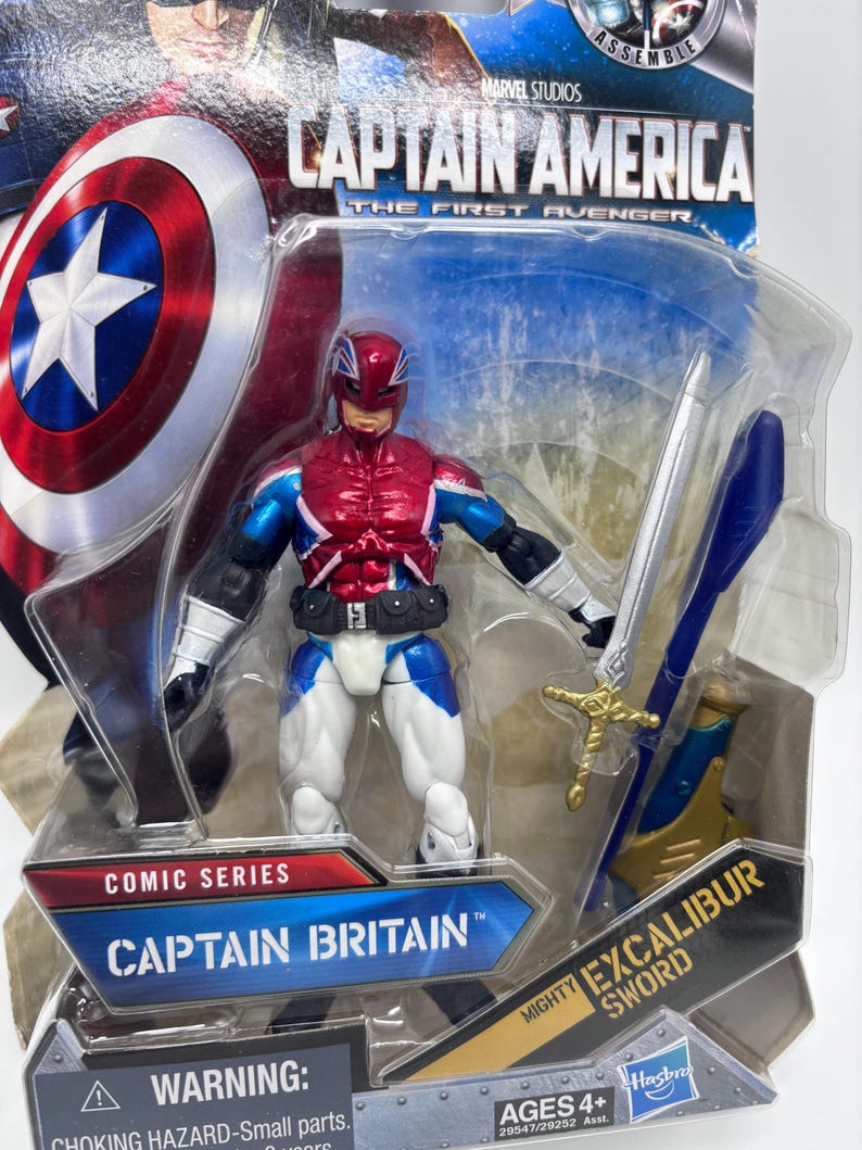 Pu&ograve; includere: Action figure di Captain Britain della serie Comic, confezionata in blister trasparente. La figura &egrave; rossa, bianca e blu, con elmetto e spada "Excalibur". La confezione include i loghi Marvel Studios e Captain America.