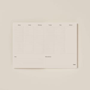 Könnte beinhalten: Ein beigefarbener Wochenplaner mit minimalistischem Design. Das Layout umfasst Abschnitte für jeden Wochentag, Notizen und Wochenziele. Der Text "TMW" befindet sich unten rechts.