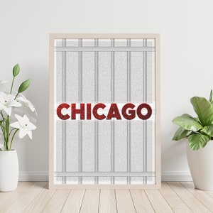 Puede incluir: Una impresión enmarcada con un fondo a rayas blanco y gris y la palabra "CHICAGO" en letras de purpurina roja.