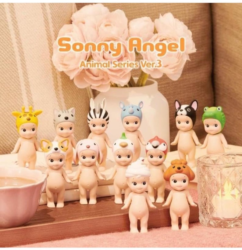 Pode incluir: Uma cole&ccedil;&atilde;o de 12 figuras Sonny Angel, cada uma com um chap&eacute;u de animal diferente. As figuras s&atilde;o todas nuas e t&ecirc;m uma express&atilde;o doce e inocente. Os chap&eacute;us s&atilde;o coloridos e apresentam uma variedade de animais, incluindo uma girafa, um gato, uma zebra, um rinoceronte, um c&atilde;o, um coelho, um frango, um pinguim, um p&aacute;ssaro, um c&atilde;o, um urso e um sapo. O texto "Sonny Angel Animal Series Ver.3" est&aacute; impresso no fundo.