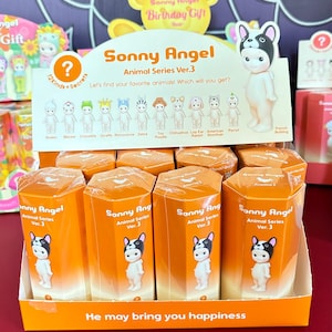 Pode incluir: Um expositor de caixas surpresa Sonny Angel Animal Series Ver. 3. Cada caixa apresenta um personagem animal diferente, incluindo um Bulldogue Franc&ecirc;s, uma Zebra, um Caniche Toy e um Chihuahua. As caixas s&atilde;o laranja e brancas com o logotipo Sonny Angel e o texto "Animal Series Ver. 3".