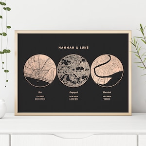 Peut inclure: Une affiche encadrée sur fond noir avec trois illustrations de cartes circulaires en or rose. Le texte indique HANNAH & LUKE, avec les mentions Met, Engaged, Married, suivies des dates 11.6.2012, 24.8.2016, 25.5.2019 et des lieux Brighton, London, Venice.