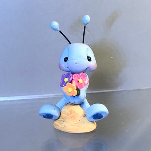 Puede incluir: Juego de tres tazas de cerámica color crema con esmalte moteado. Cada taza presenta un diseño floral pintado a mano en tonos azules, verdes y amarillos. Las tazas tienen una forma sencilla y moderna.