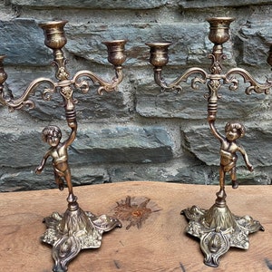 Pair of brass cherub candlestick holders