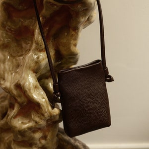 small black vertical shape leather bag with long handle o be worn as cross-body bag.