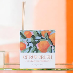 May include: A fragrance diffuser box with a citrus fruit design. The box features orange fruit illustrations with green leaves on a blue background. The text "Citrus Crush" and "7 oz Fragrance Diffuser" are printed on the front.