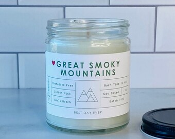 Könnte beinhalten: Ein Kerzenglas mit schwarzem Deckel. Das Etikett trägt die Aufschrift "Great Smoky Mountains" mit einem Herzsymbol. Merkmale sind ein Baumwolldocht, Sojawachs und ein Volumen von 198g. Der Text "Best Day Ever" steht ebenfalls auf dem Etikett.