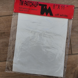 May include: Off-white self-adhesive leather repair patch, 8" x 11", in a clear plastic package. The red header reads "TM PATCH-UP" with the TM logo and product dimensions. The patch is off-white.