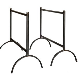 May include: Two black metal table bases with arched legs. The bases are made of sturdy metal and have a simple, industrial design.