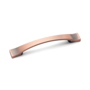 May include: A brushed copper cabinet pull with a slightly curved shape and squared ends.