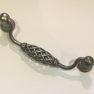 May include: Antique silver cabinet pull with a decorative wire mesh design and rounded ends.