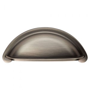 May include: A silver cup-shaped cabinet pull with a brushed finish.