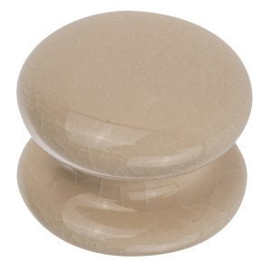 May include: A beige ceramic knob with a smooth, rounded surface. The knob has a slightly raised centre and a flat bottom.