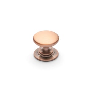 May include: A copper cabinet knob with a round, slightly domed top and a smaller, round base.