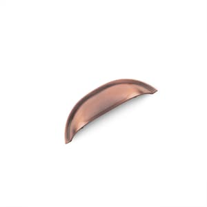 May include: A copper cabinet pull with a curved, slightly rounded shape. The pull has a brushed finish.