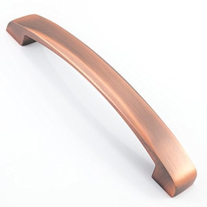 May include: A curved copper cabinet pull with a smooth, brushed finish. The pull has a rounded rectangular shape with slightly rounded edges.