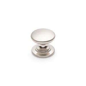 May include: A silver cabinet knob with a round, slightly domed top and a smooth, polished finish.