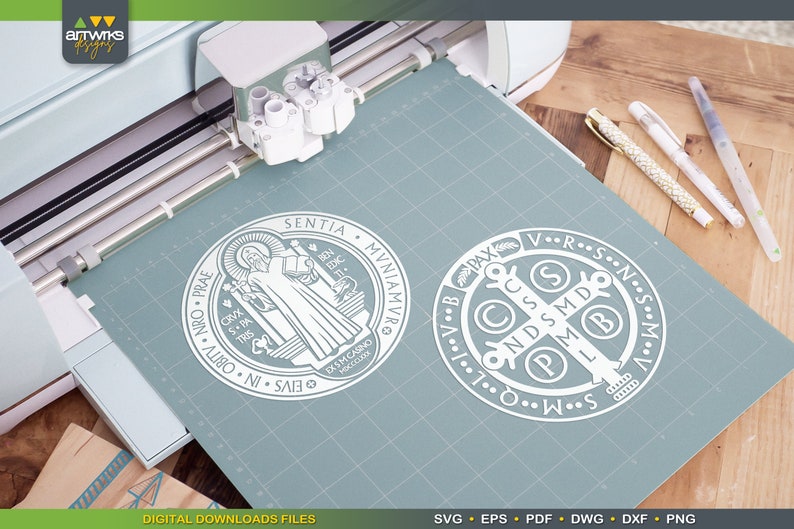 May include: A white outline of the Saint Benedict Medal and the Saint Benedict Cross on a blue background. The Saint Benedict Medal features the image of Saint Benedict holding a book and a cross. The Saint Benedict Cross features the letters "V.R.S.N.S.M.D.P.M.L.I.C.C.S.P.X.A.V.B."