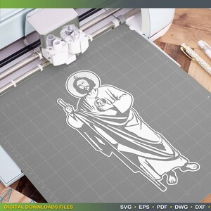 Puede incluir: Una silueta blanca de una figura religiosa con un halo, sosteniendo un bast&oacute;n y un coraz&oacute;n en su mano. La figura est&aacute; de pie sobre un fondo gris.