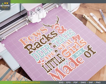May include: A pink cutting mat with a design that says "Bows & Racks Deer Tracks are what Little Girls are Made of" in various colors and fonts. The design includes a deer antler, a bow, and hearts.