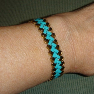 Turquoise and bronze woven bead bracelet has gold plated slide lock clasp.