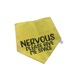 May include: Yellow dog bandana with black text that reads "NERVOUS PLEASE GIVE ME SPACE".