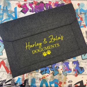 May include: Grey felt folder with a yellow flap and the text "Harley & Zola's DOGUMENTS" with two yellow paw prints.