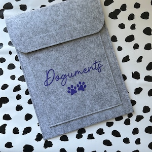 May include: Gray felt document folder with a blue paw print design and the word "Documents" written in cursive.